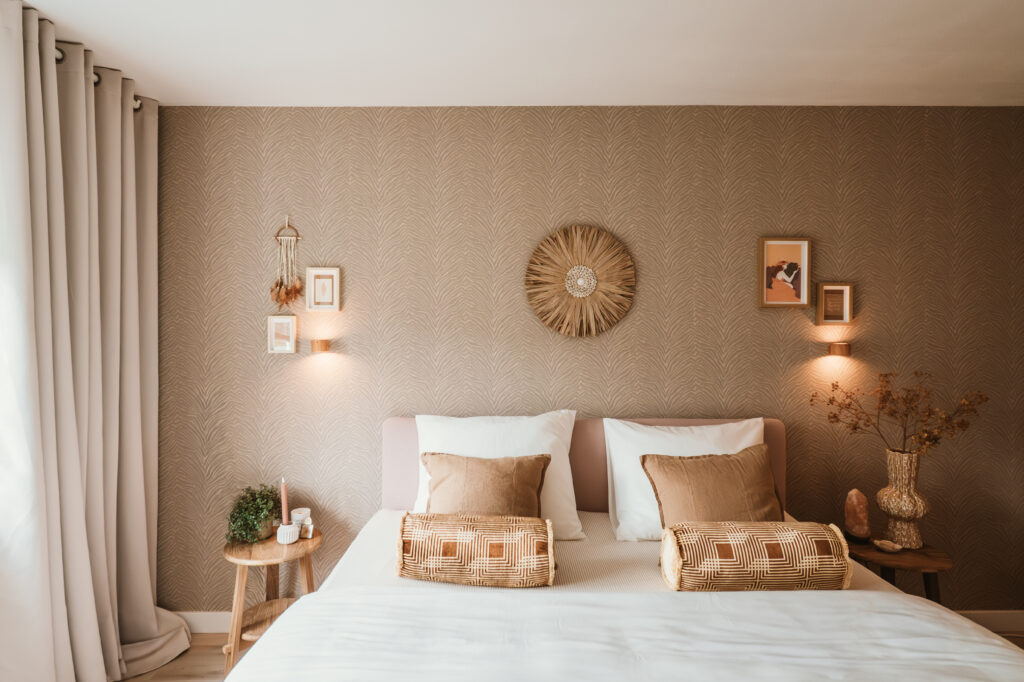 Sfeervol interieurontwerp van een warme slaapkamer met een opgemaakt bed en behang met print.