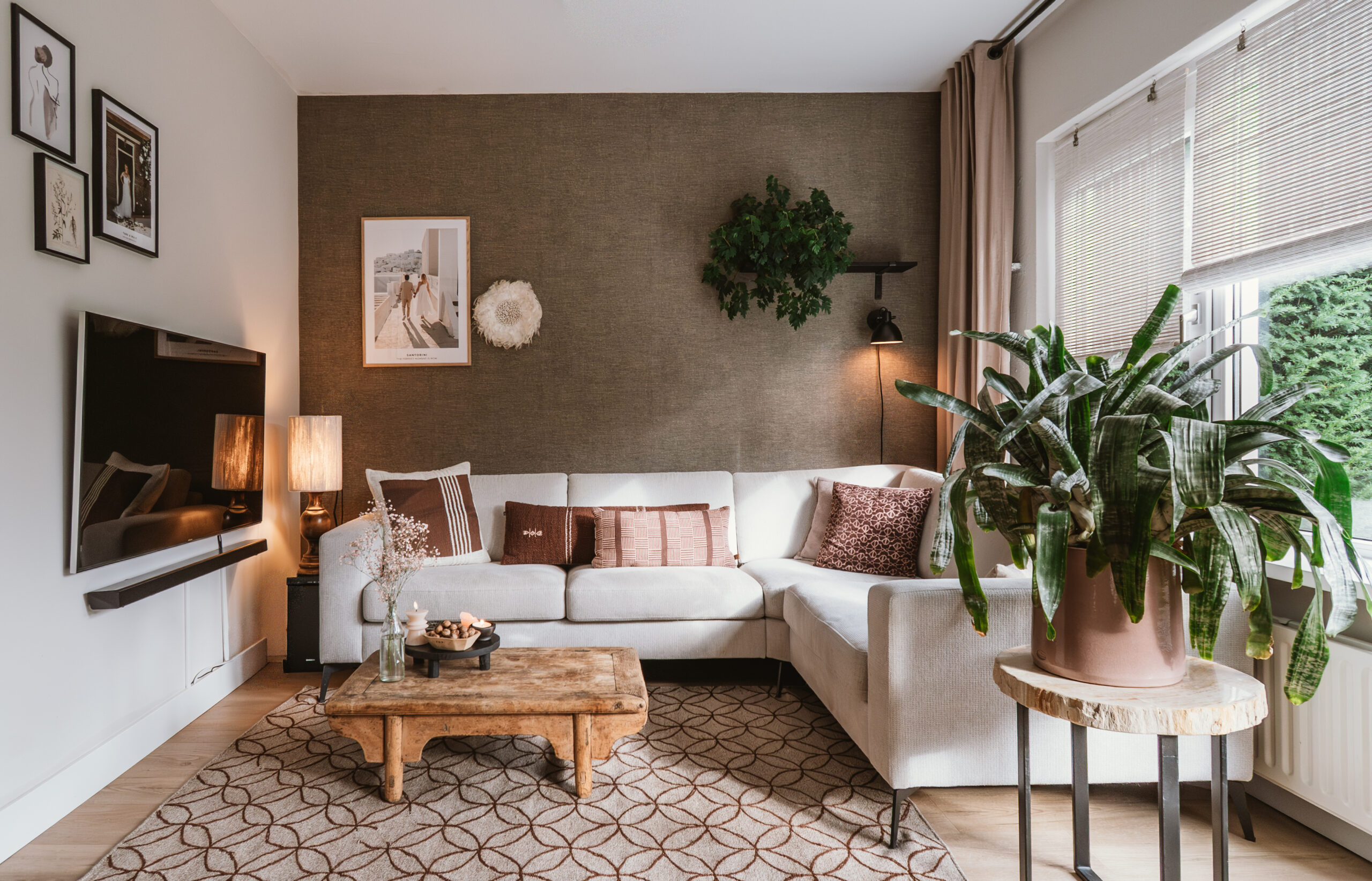 Interieurontwerp van een lichte woonkamer met abstracte wandkunst boven de bank.